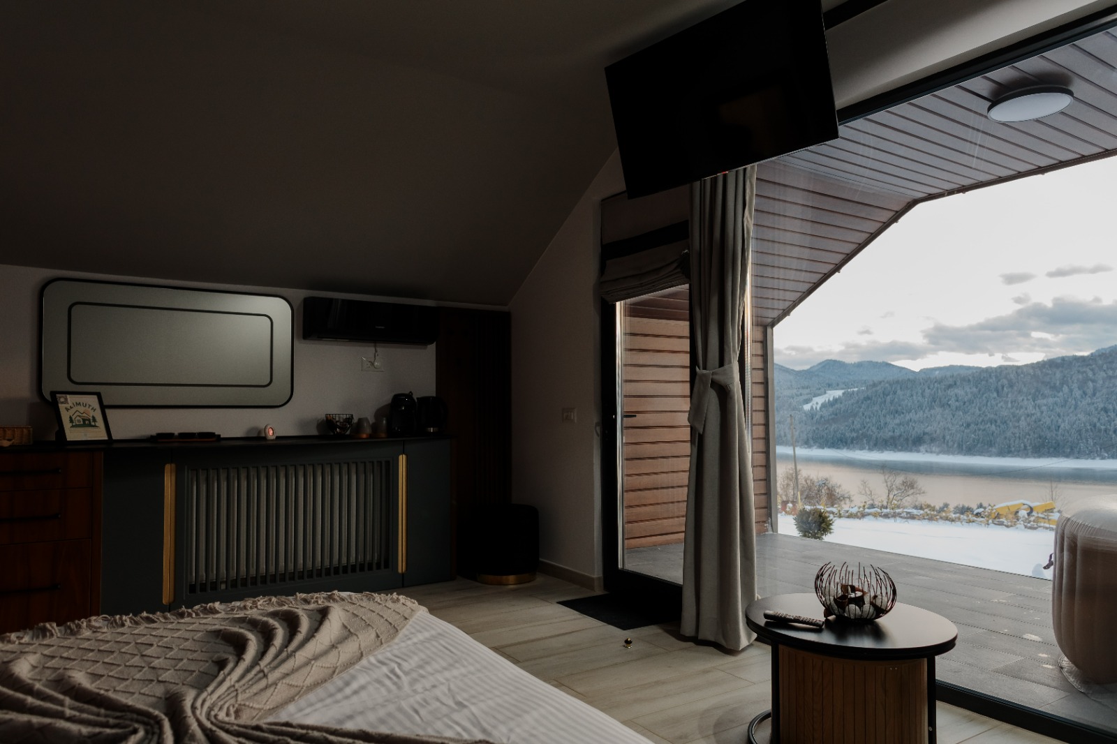 Interiorul dormitorului cu fereastră mare și vedere panoramică la lacul Bicaz
